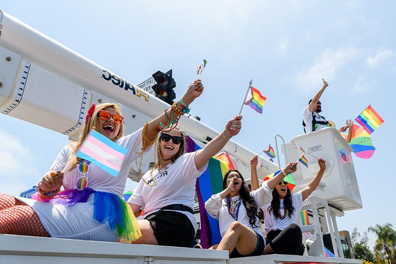 Sempra and SDG&E team members wave to the crowd from a bucket truck during the 2022 San Diego Pride parade